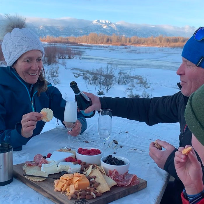 Family Enjoying Charcuterie Plate on Snowcat Picnic with Wyo Cat Skiing